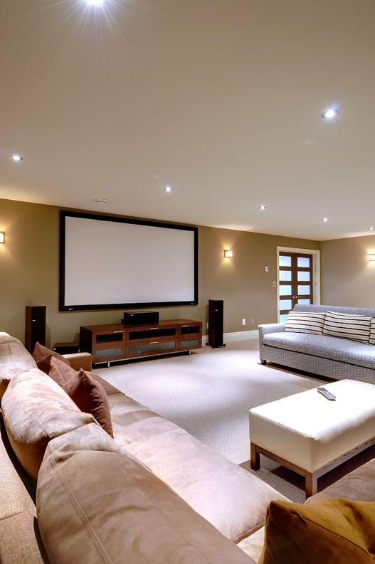 Fixed screen family room home theatre system with Lutron lighting control.